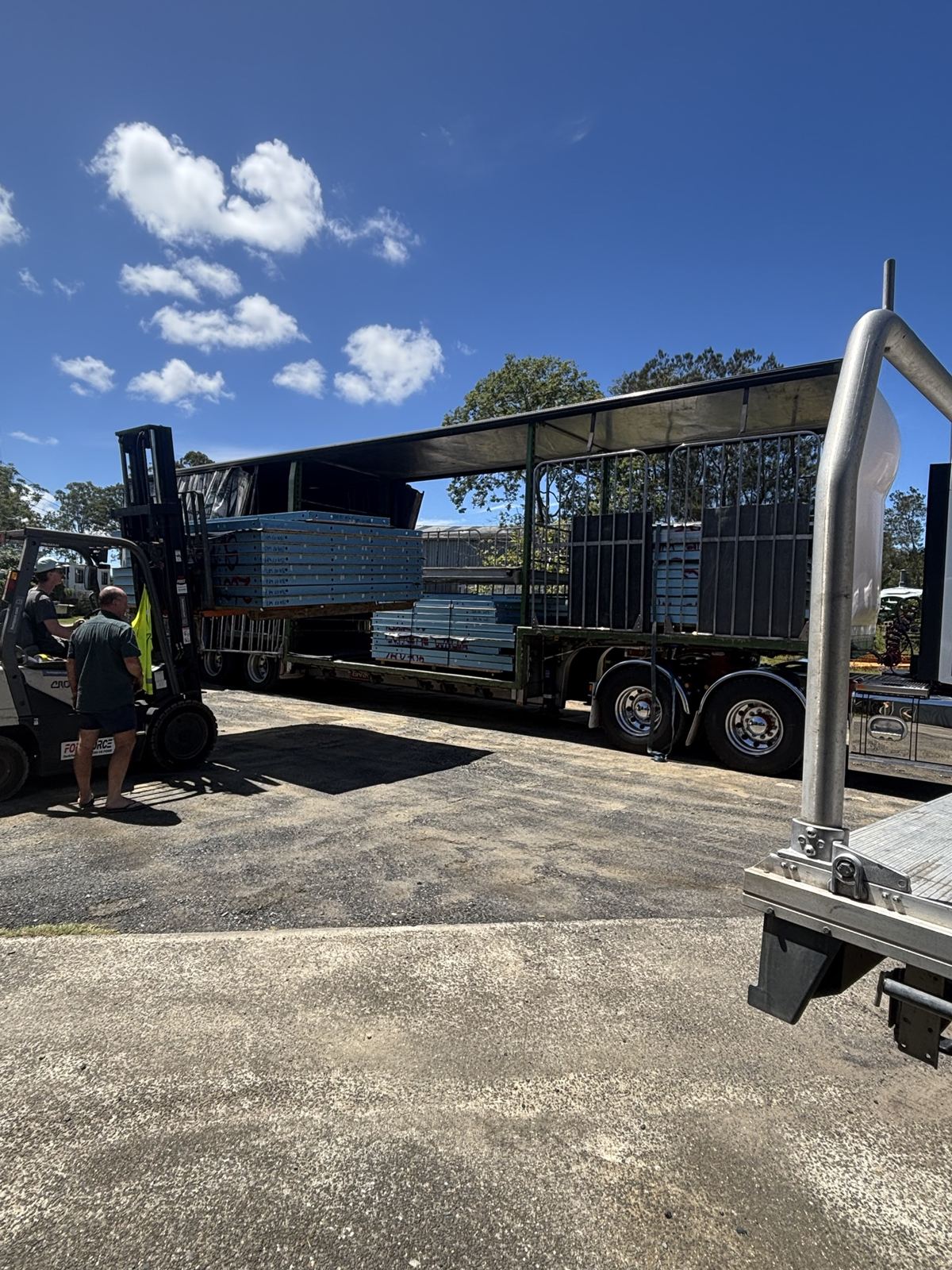 A forklift loading panel stacks onto a semi trailer at the factory