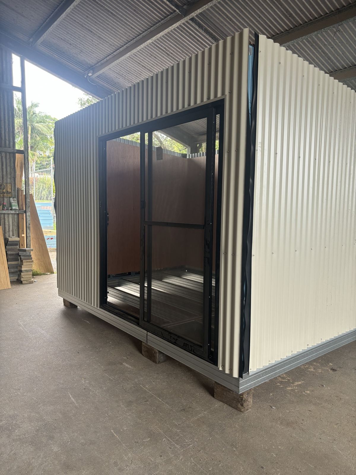 A studio built from Supreme Walls corrugated panels with a black sliding door, in the West Ballina factory