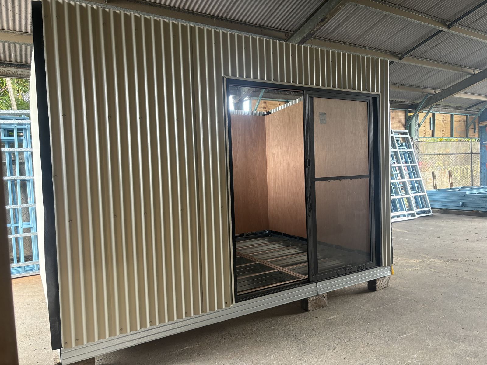 Front of a corrugated studio with a sliding door, built from Supreme Walls panels