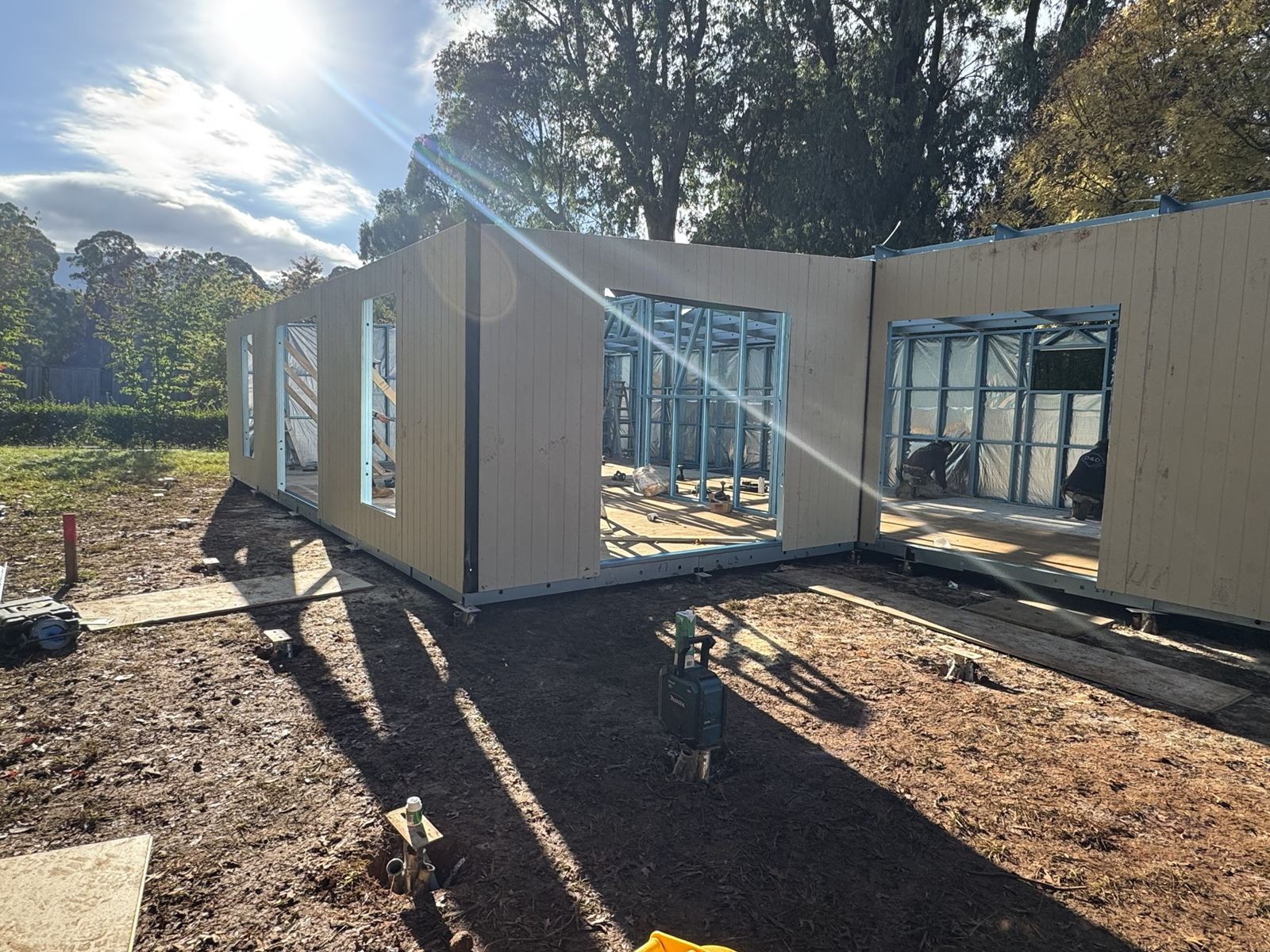 A row of clad panels with openings, standing on site